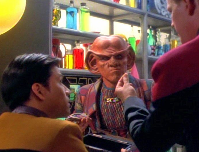 Background, Quark the bartender looking all huffy. Foreground, Harry Kim and Tom Paris all sure that they're going to be on the good series.