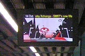 Close-up on the train-arriving monitor as it shows some advertisement, surely, that involved some big alien-ish monster sprawling out.