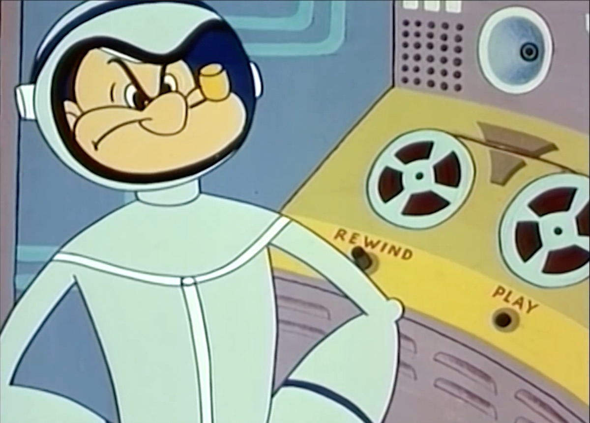 Popeye, in a spacesuit, looking angrily at the camera. Behind him is a reel-to-reel tape with two buttons on the player, Rewind and Play.