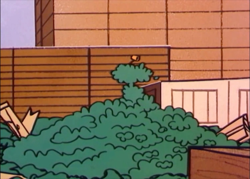 Heap of spinach spilled over a box. Sitting up is a silhouette of Popeye in spinach; just his pipe is clear and not covered in the leafy green vegetables.
