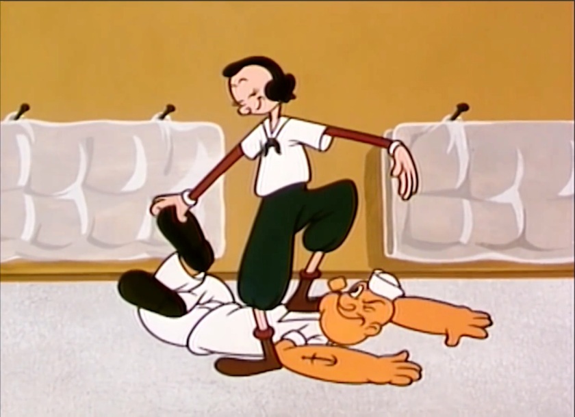 Olive Oyl stands, confident and proud, atop Popeye, who's on the floor, on his belly, looking back with admiration up at her. She's got Popeye's legs twisted together, as though she had beaten him wrestling.